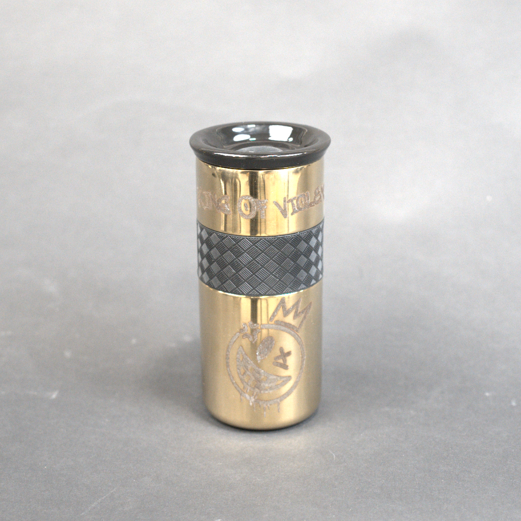 Gold and black cylindrical object on a gray background