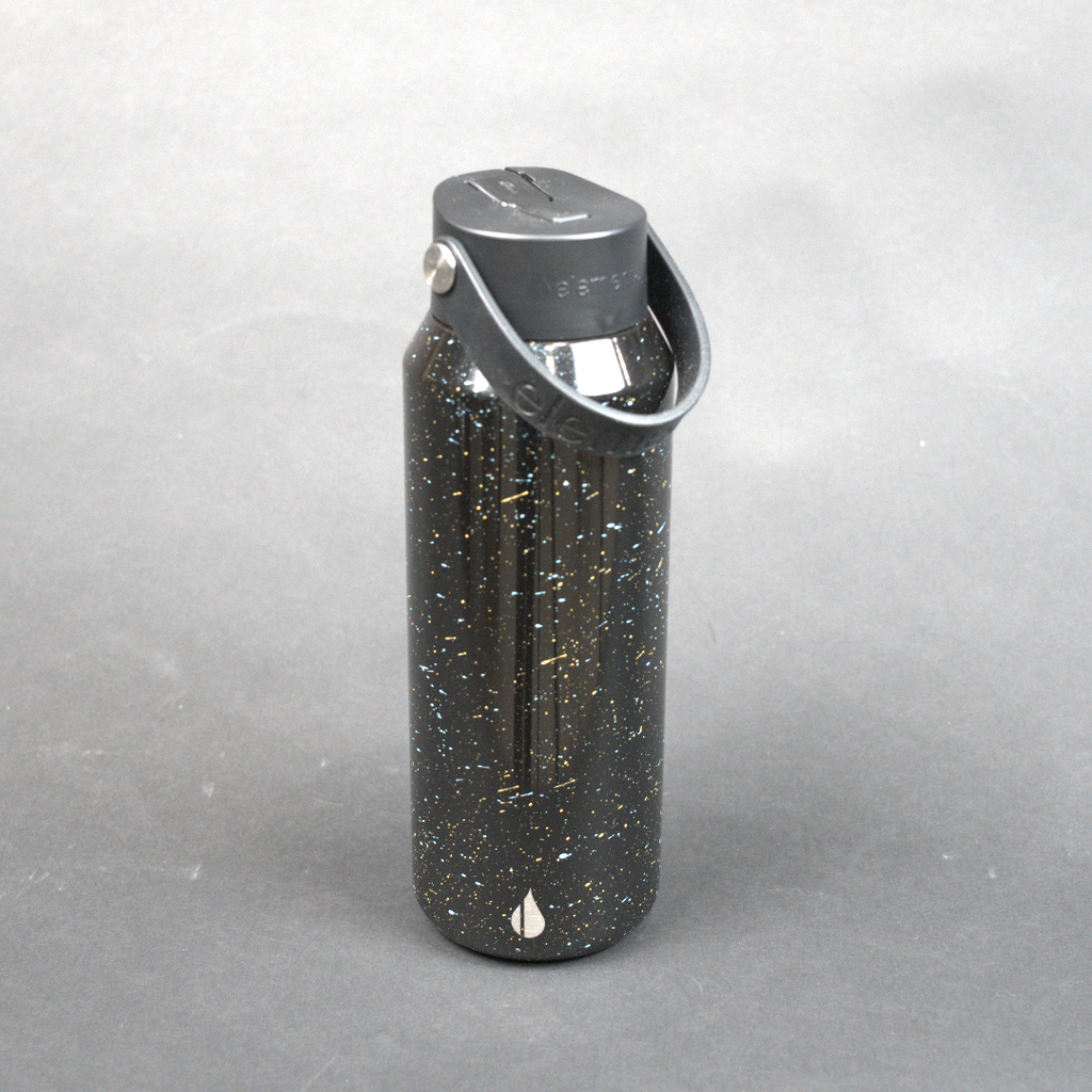 Black speckled water bottle with silver cap on a gray background