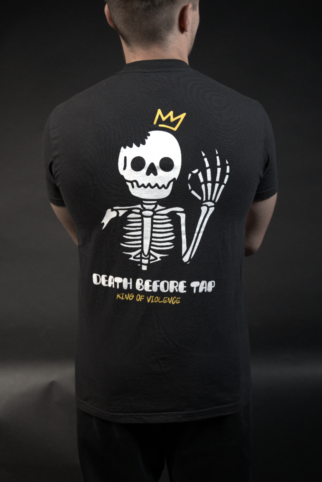 Person wearing a black hoodie with a skeleton design and text on a dark background